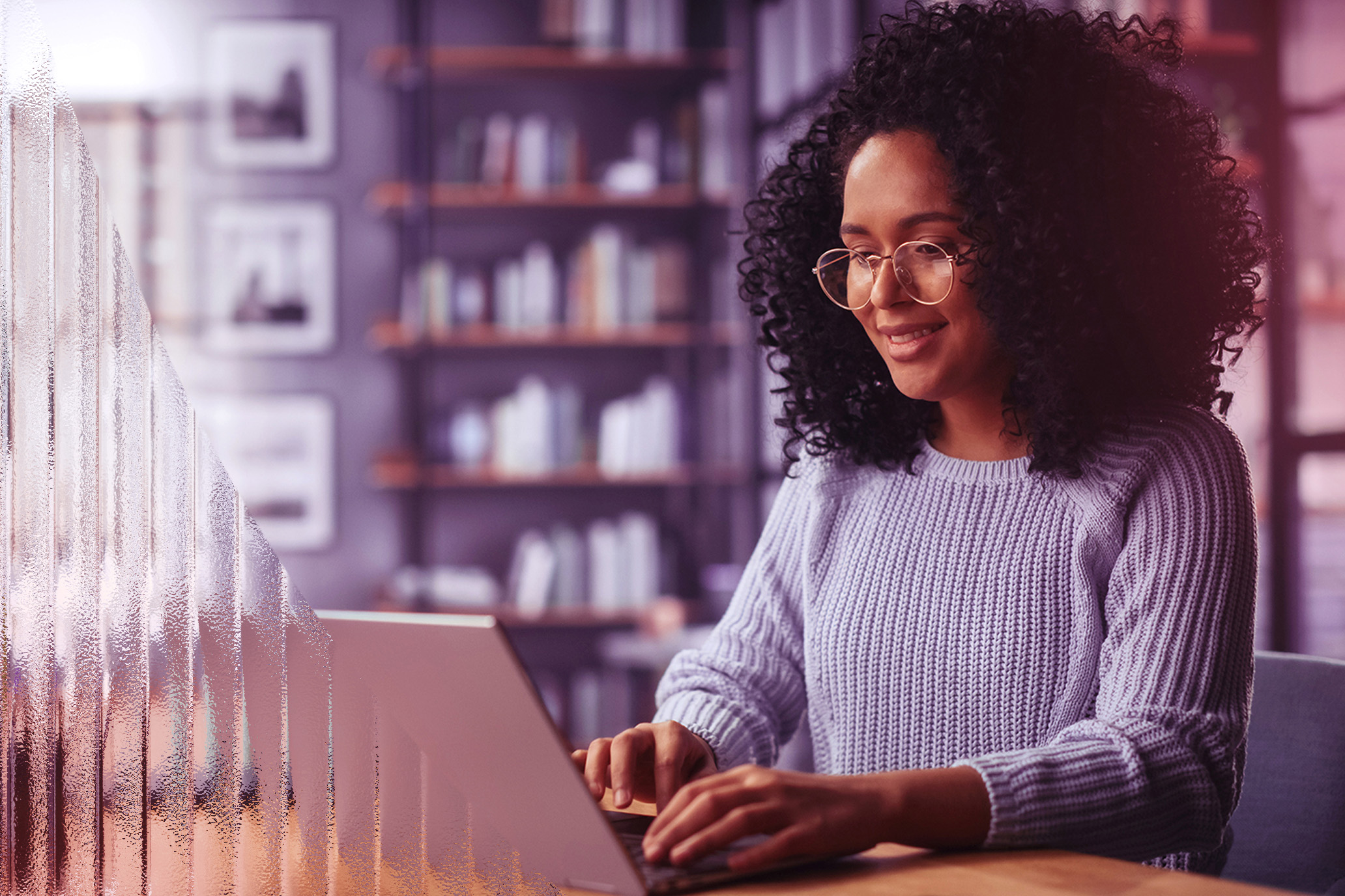 Curly haired girl typing on her laptop
