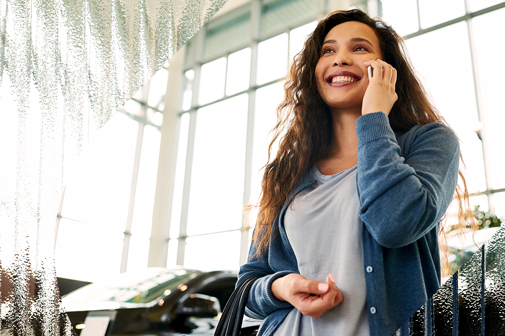 Image of a woman making a phone call from the car dealership