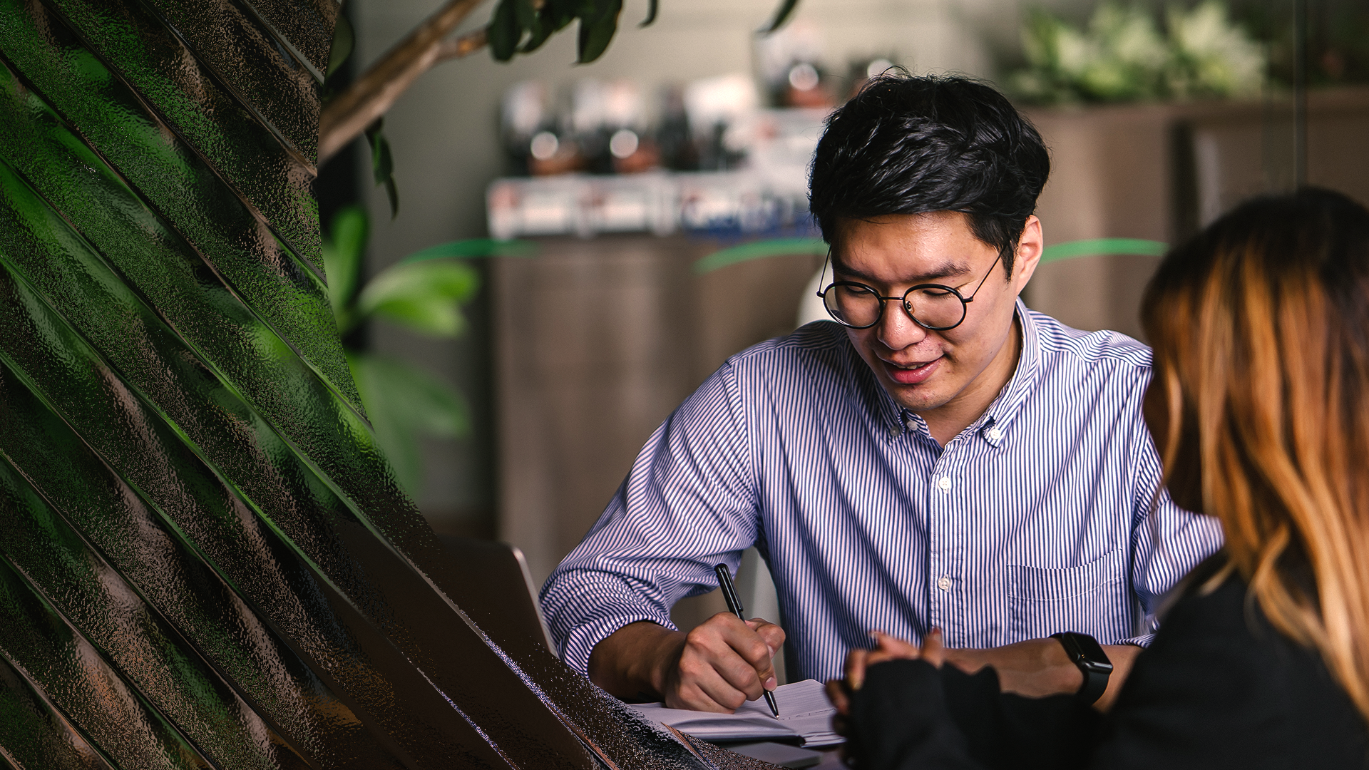Image of a young man writing on a notebook